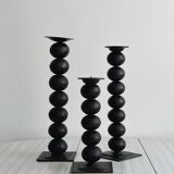 three designer candle holders in matte black metal