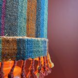 "Stoneware Bottle Lamp" with a multicoloured blue lampshade handwoven in India.