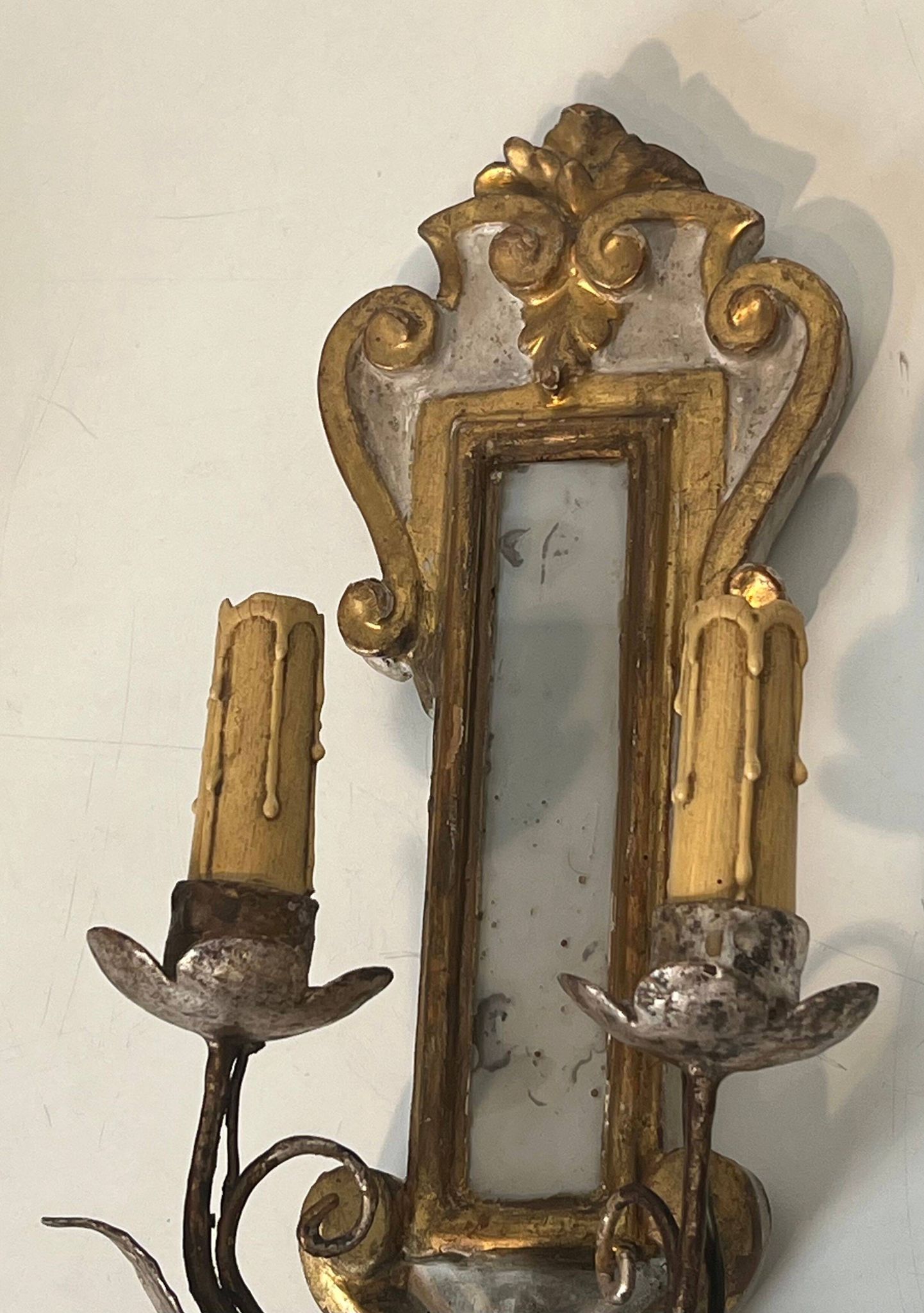 Pair of wall sconces in carved wood and silvered and gilded patinated metal with a central mirror.
