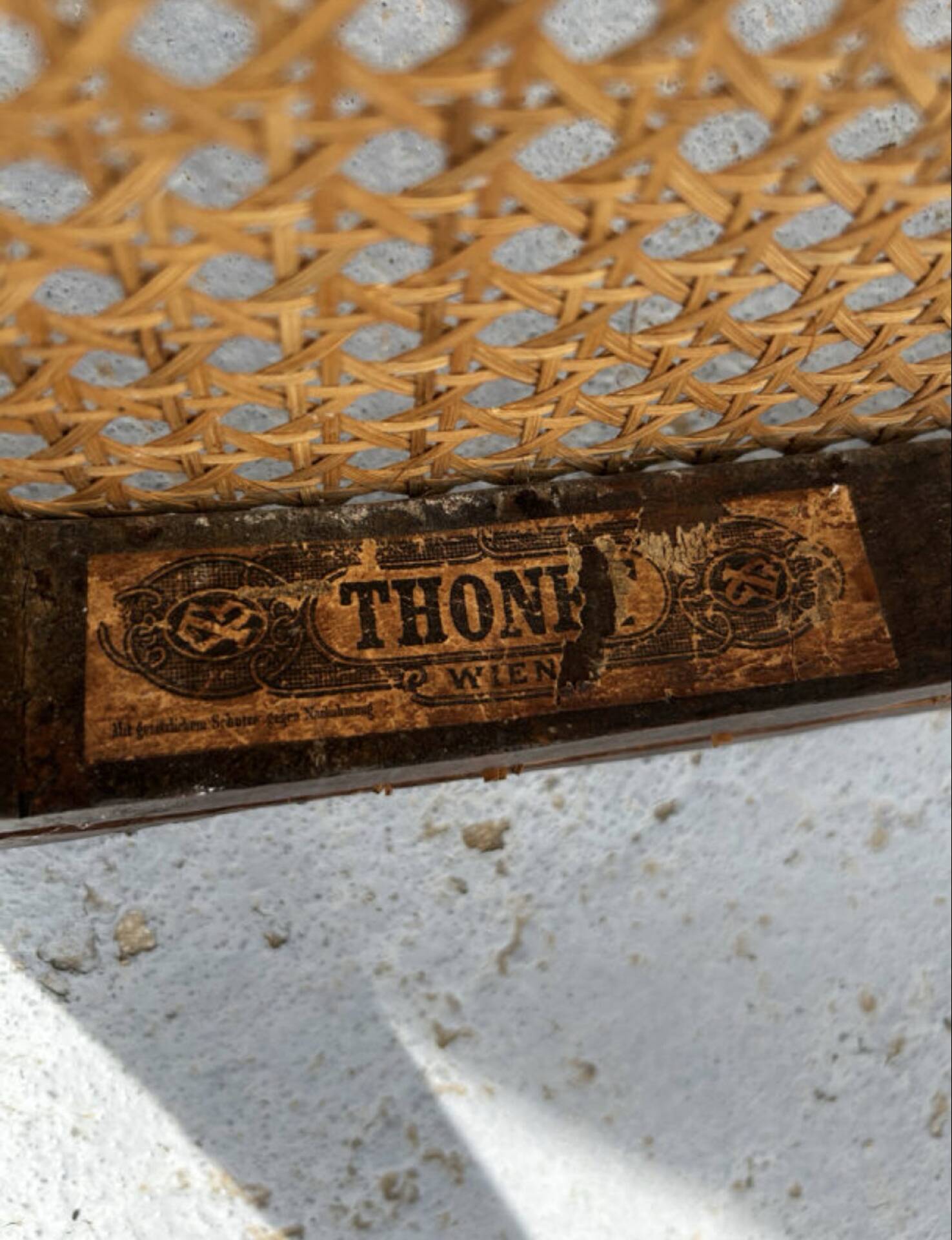 Thonet armchair stamped with curved wooden armrests and caning from the 19th century.