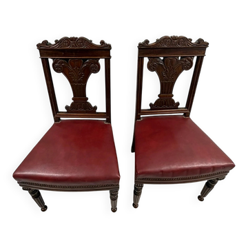 Paire de chaises en acajou sculpté, assise simili cuir rouge