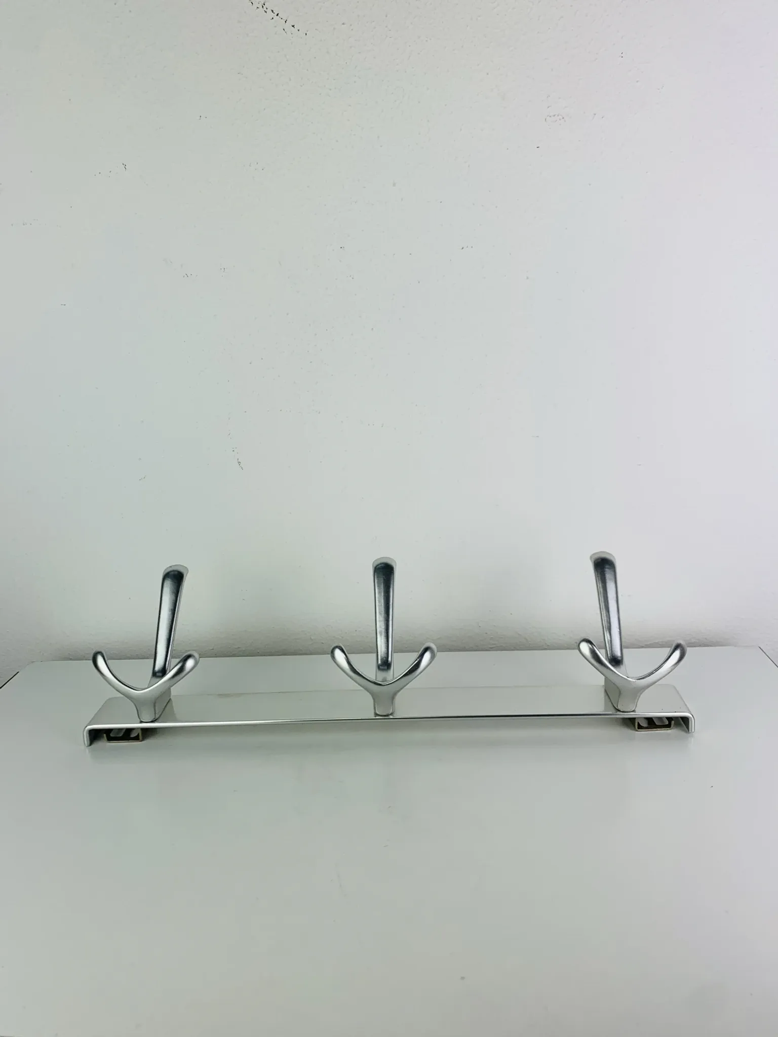 Wall-mounted coat rack, strip of 3 aluminium hooks from the 1960s.