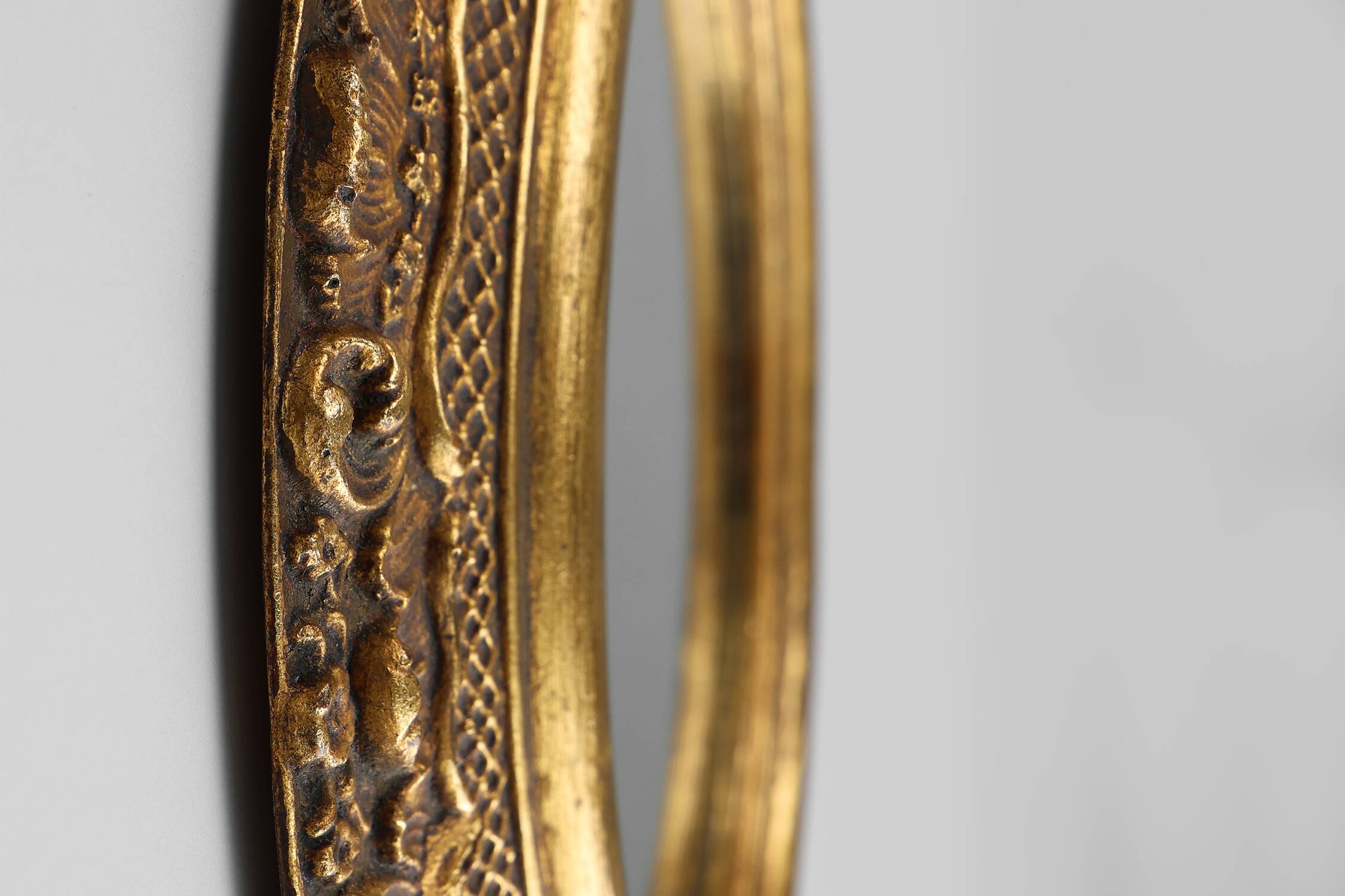 French Baroque style oval mirror in gilded wood with floral decorations
