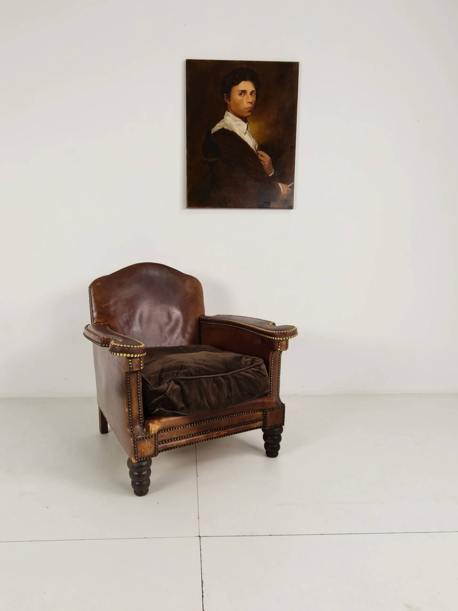 Antique leather club chair with stud detailing