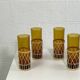 Vintage service for orangeade in amber glass and wicker.