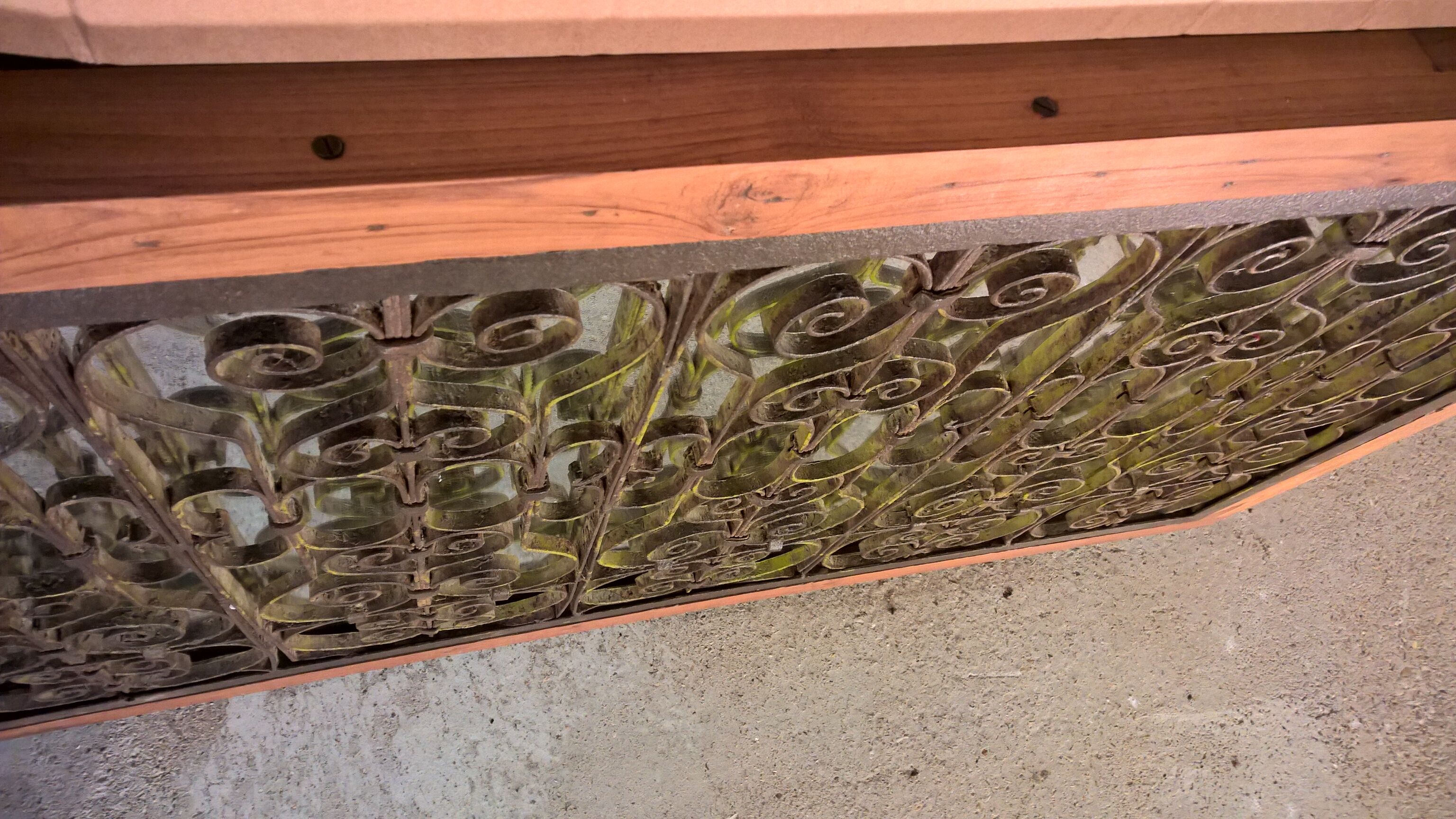 Old wrought iron railing with mirror and teak frame