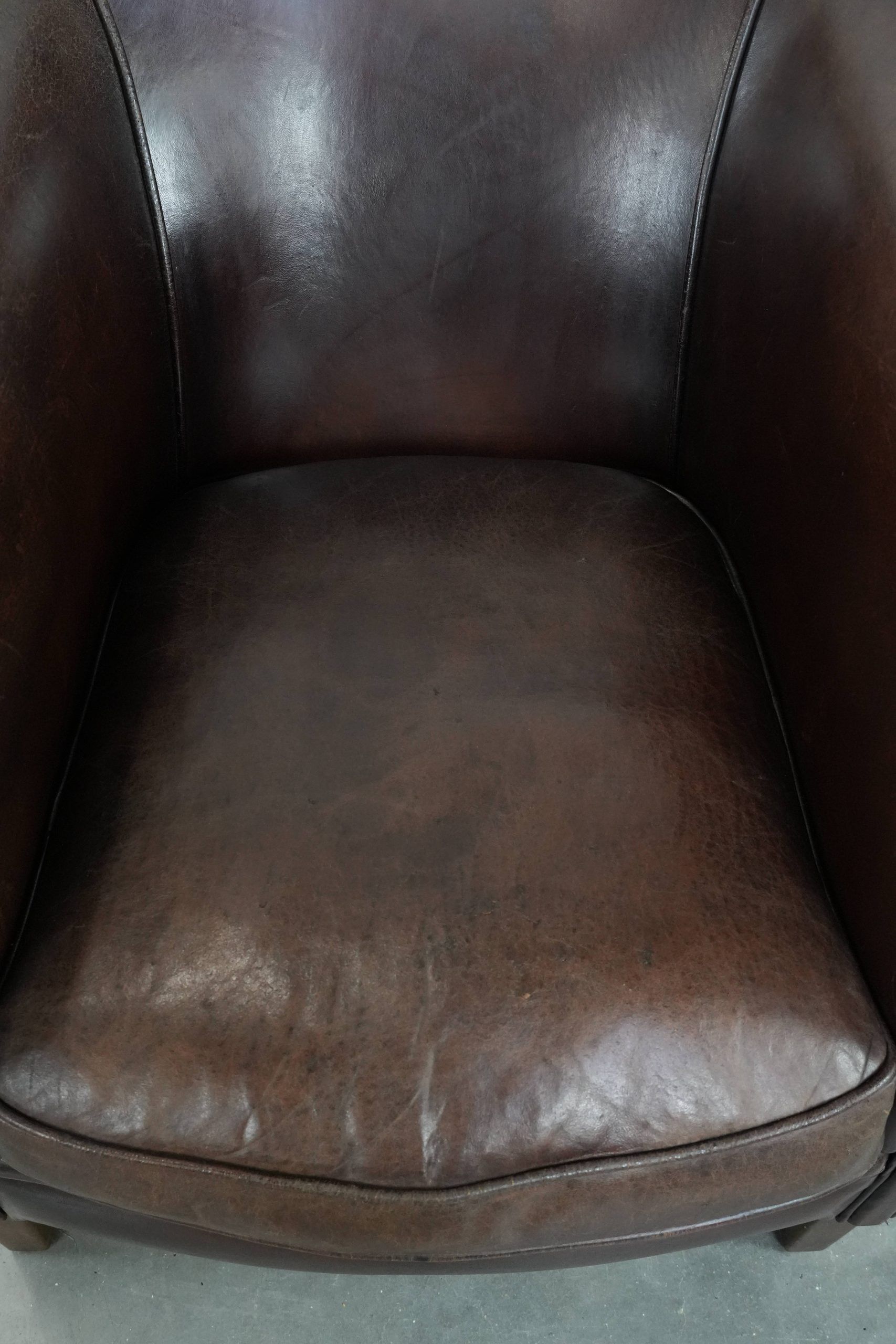 Stylish and sturdy dark brown club armchair made of sheepskin leather