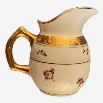 Porcelain milk jug with floral decoration on almond green and Art Deco gold background