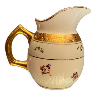 Porcelain milk jug with floral decoration on almond green and Art Deco gold background