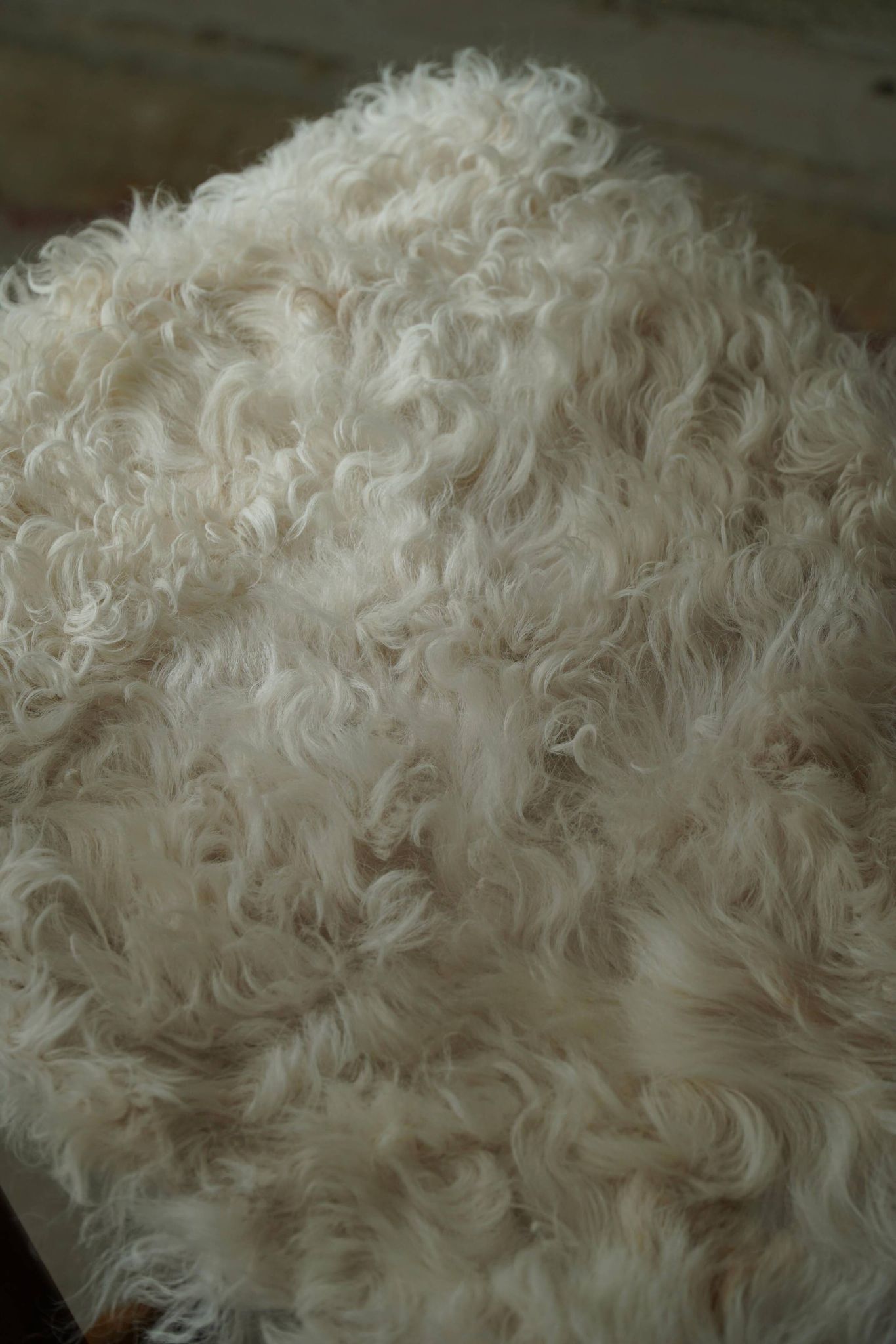 Folding stool, reupholstered in long-haired sheepskin, mid-century modern style, 1950s.