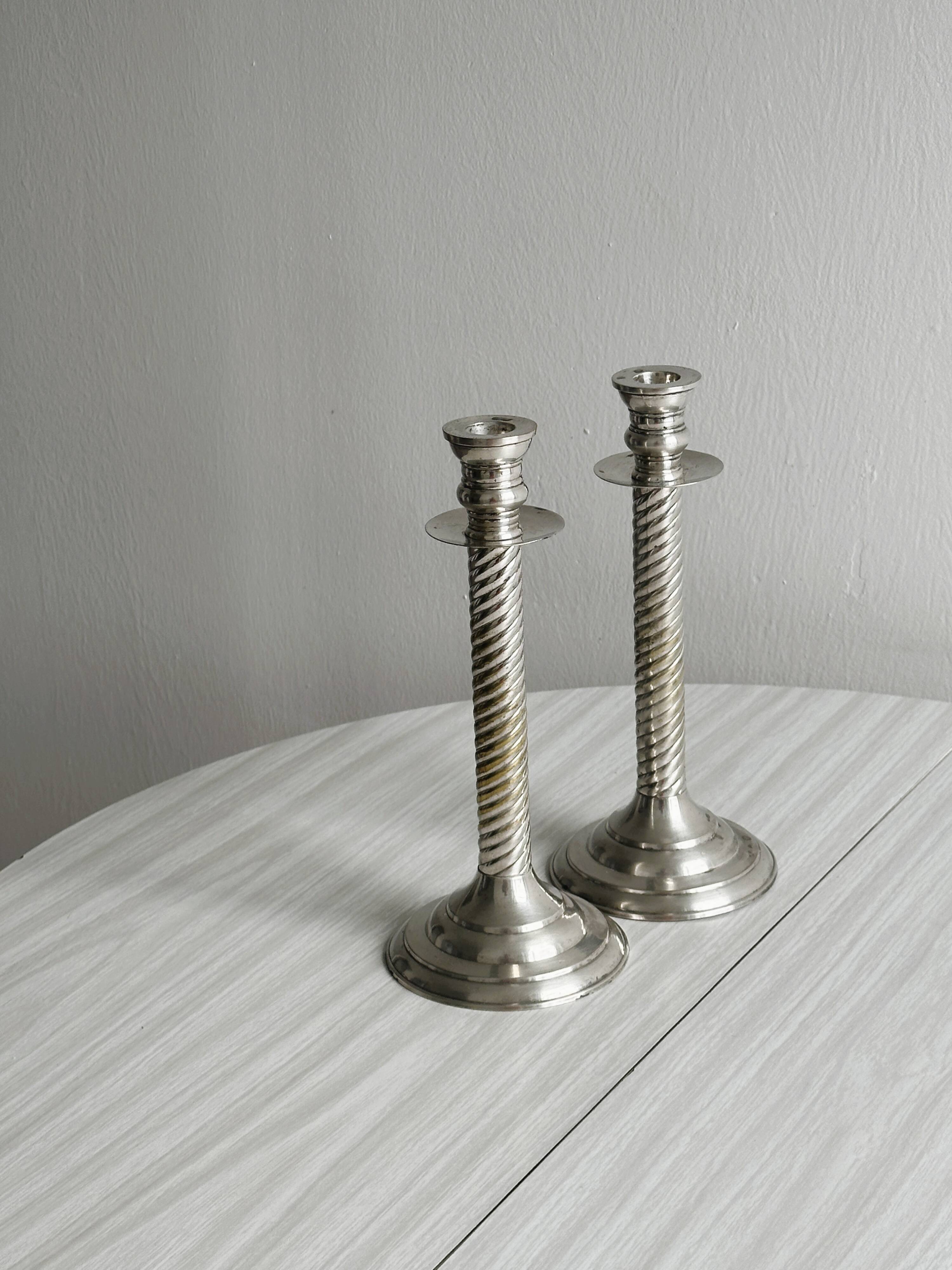 Patinated silver-plated metal candlesticks