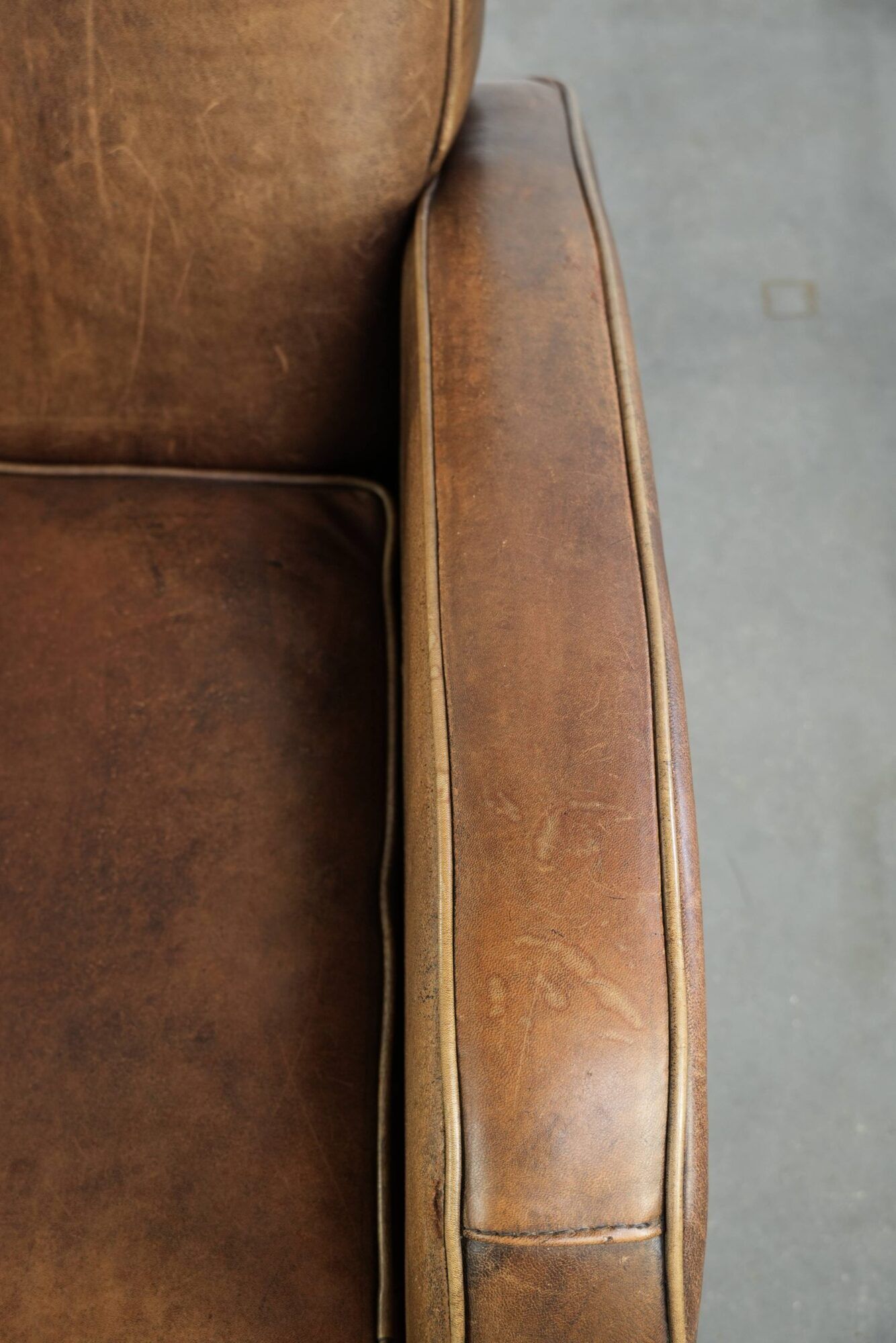 Sheepskin armchair in a light cognac colour with matching piping
