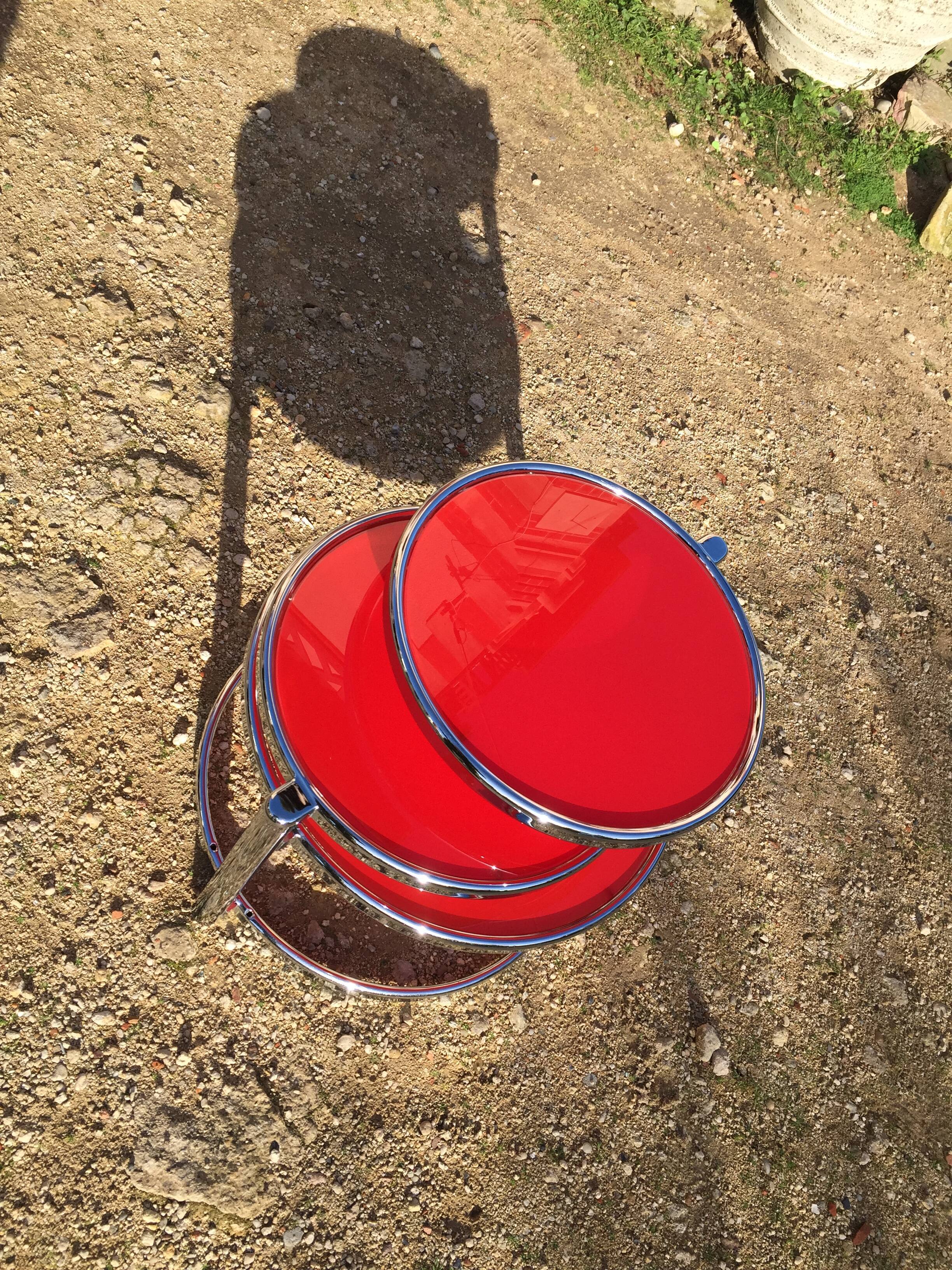 Table basse trois plateaux pivotants en verre rouge et métal chromé