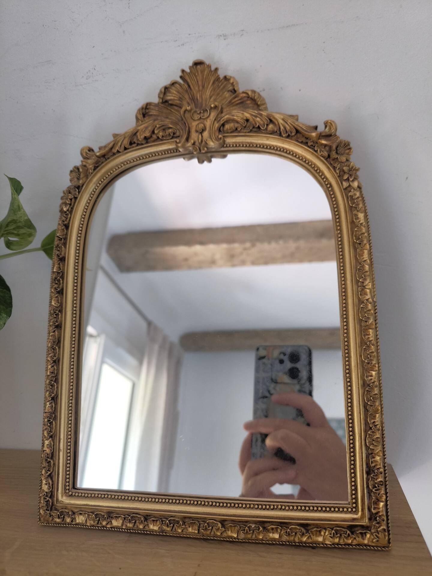 Miroir décoratif avec moulures et fronton.