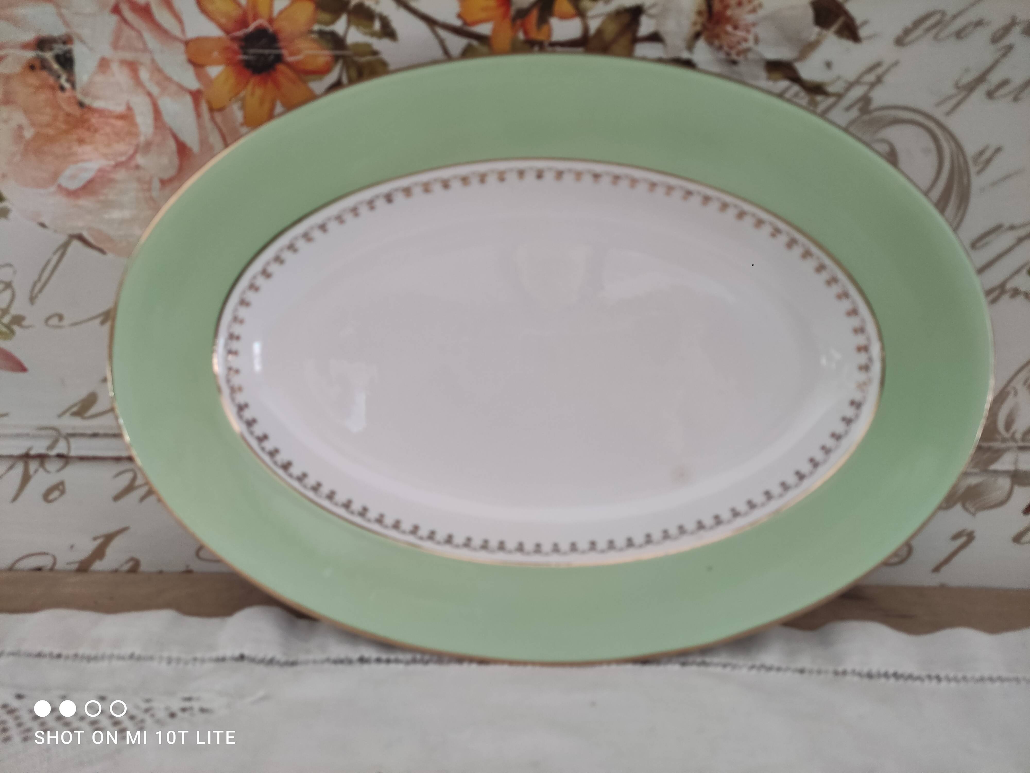 Oval plate with a light green rim and golden frieze, Cafés Lemaire.