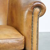 Comfortable, cozy, warm colored sheepskin club chair finished with decorative nails