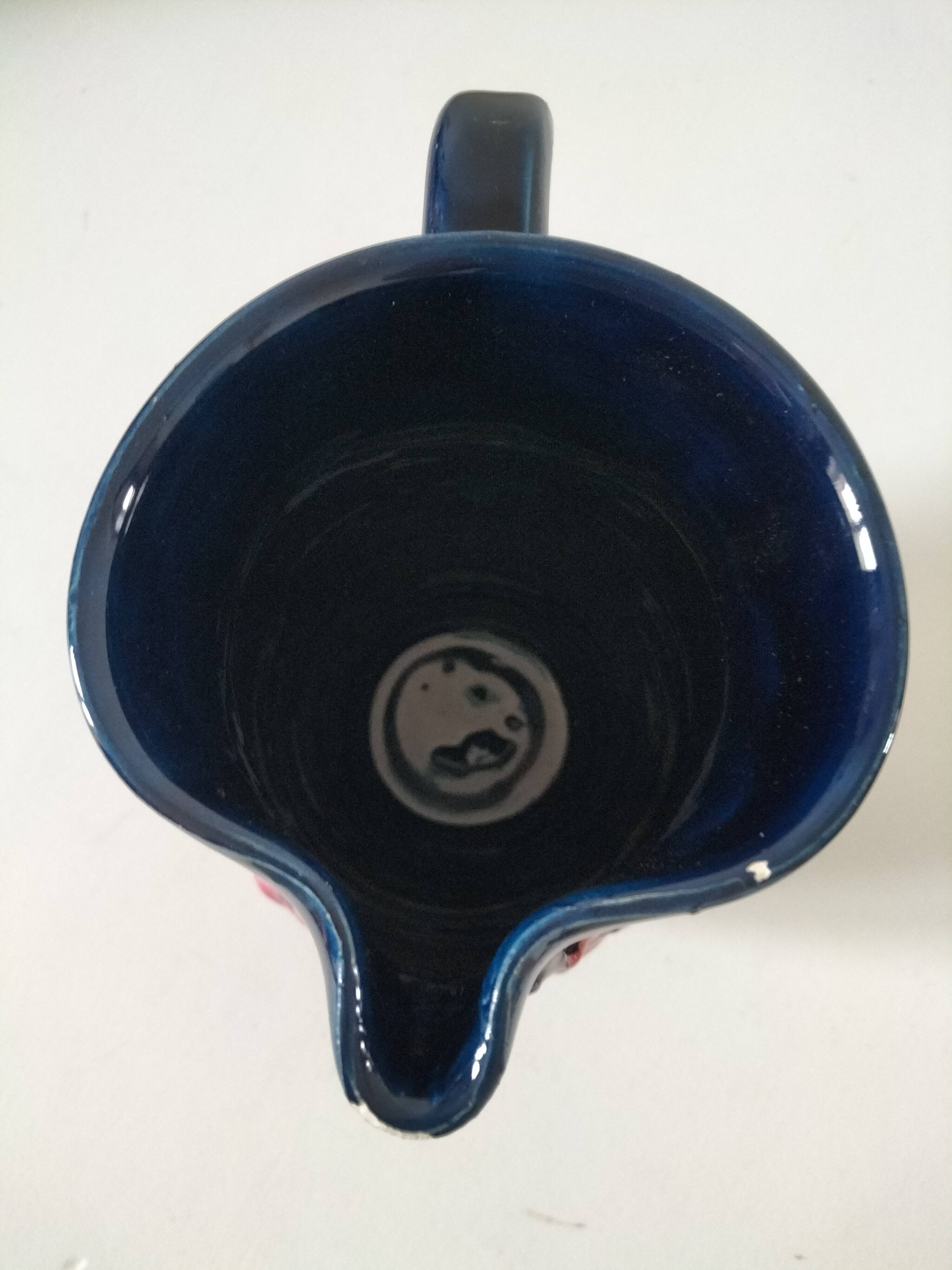 Vintage pitcher in midnight blue glazed ceramic with bright pink relief