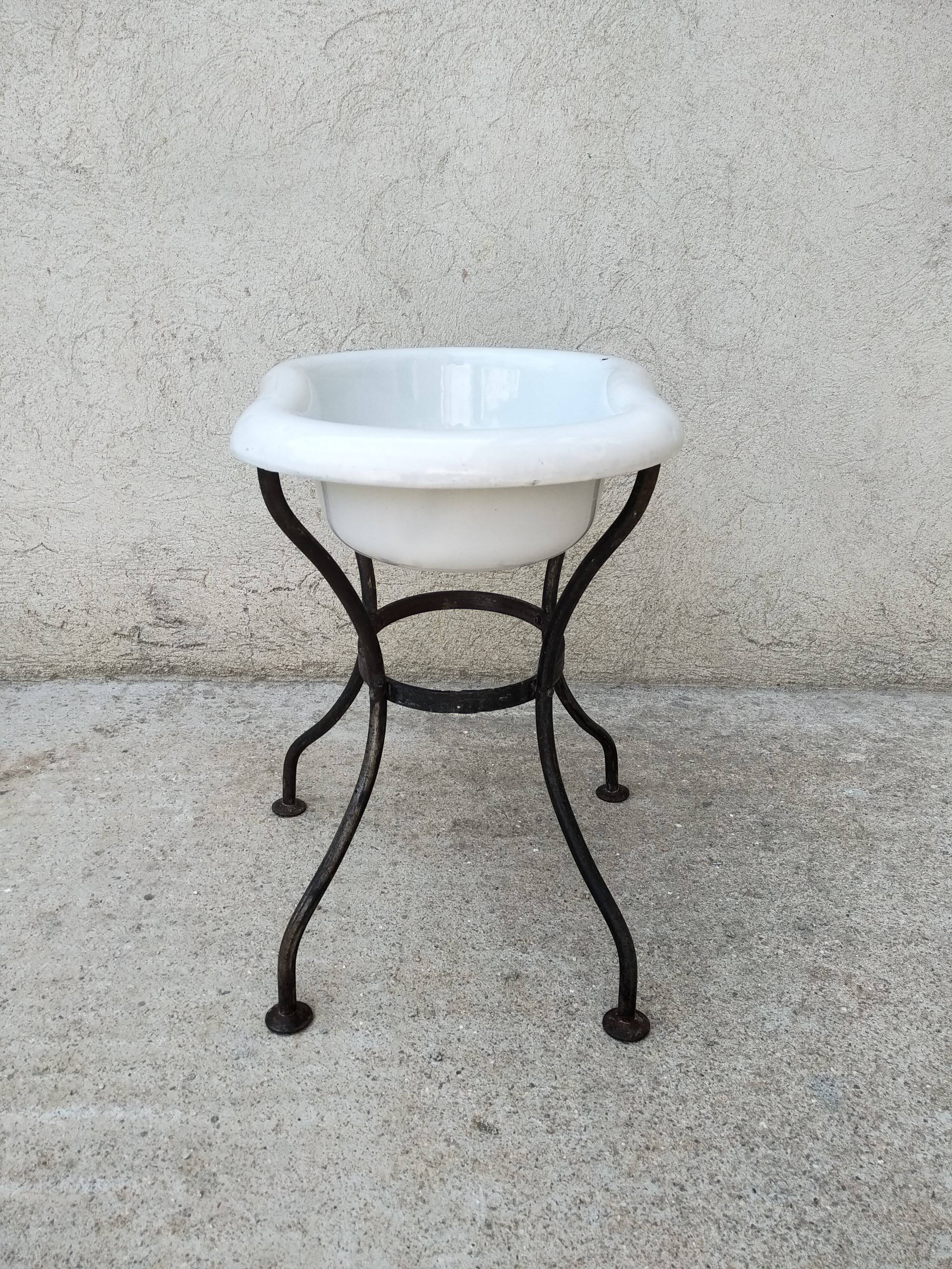 Antique bidet in enamelled sheet metal with wrought iron support