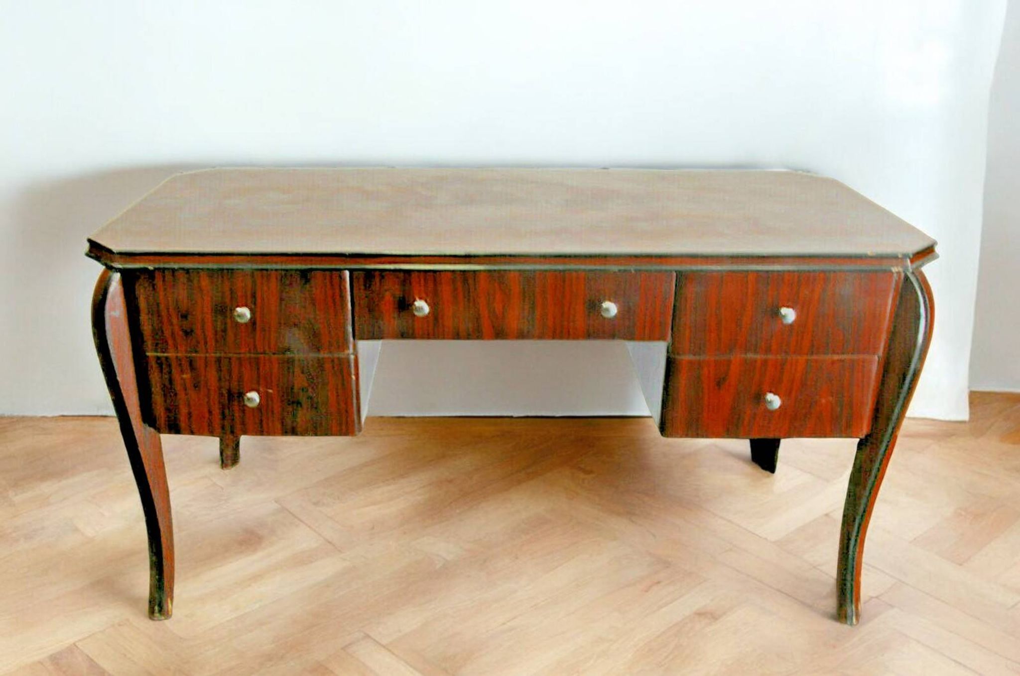 A large Art Deco style rosewood desk with 5 drawers and decorative motifs