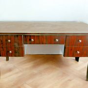 A large Art Deco style rosewood desk with 5 drawers and decorative motifs