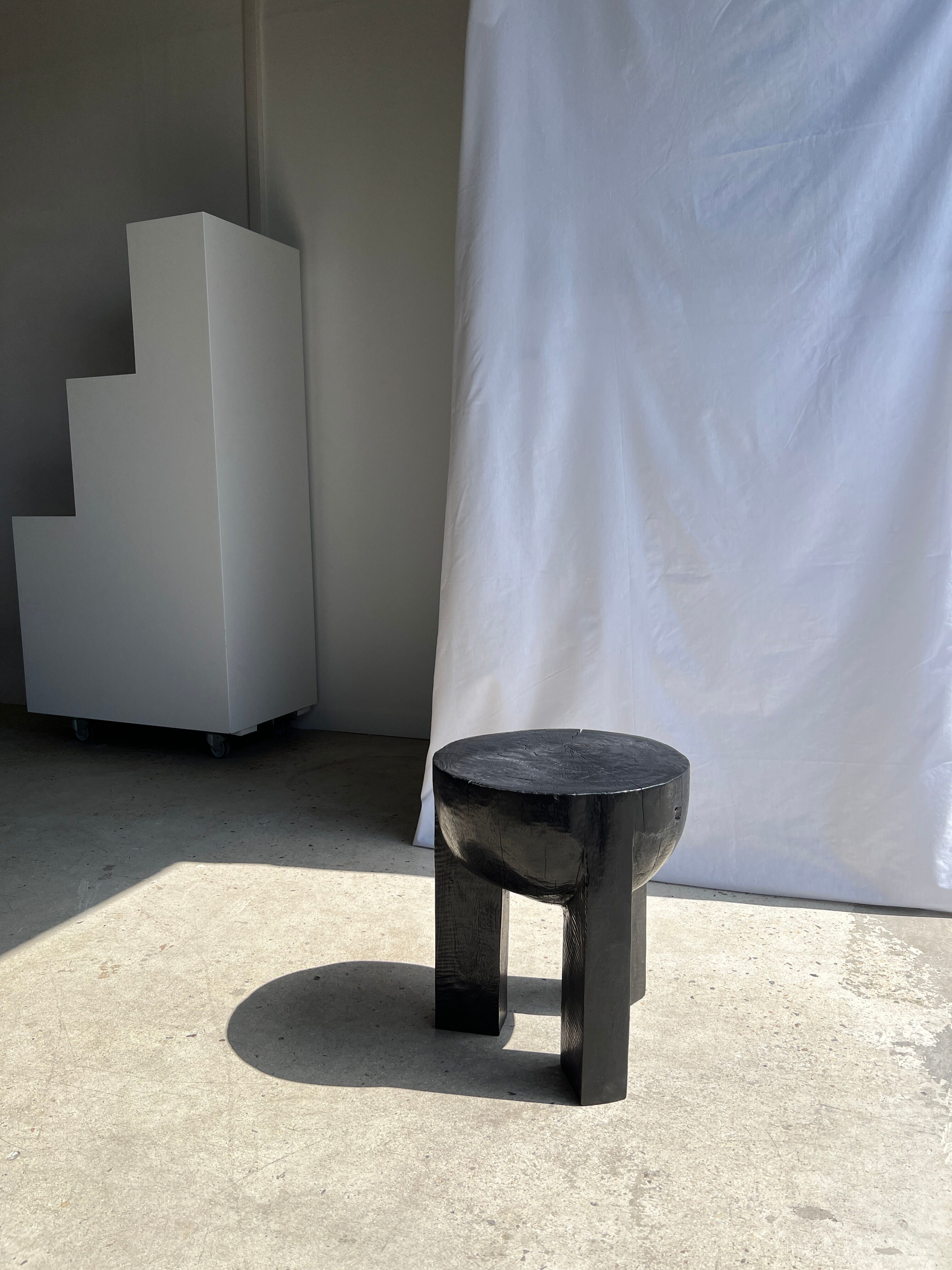 Black mango wood tripod side table with a semi-spherical top, height: 45 cm, diameter: 44 cm.