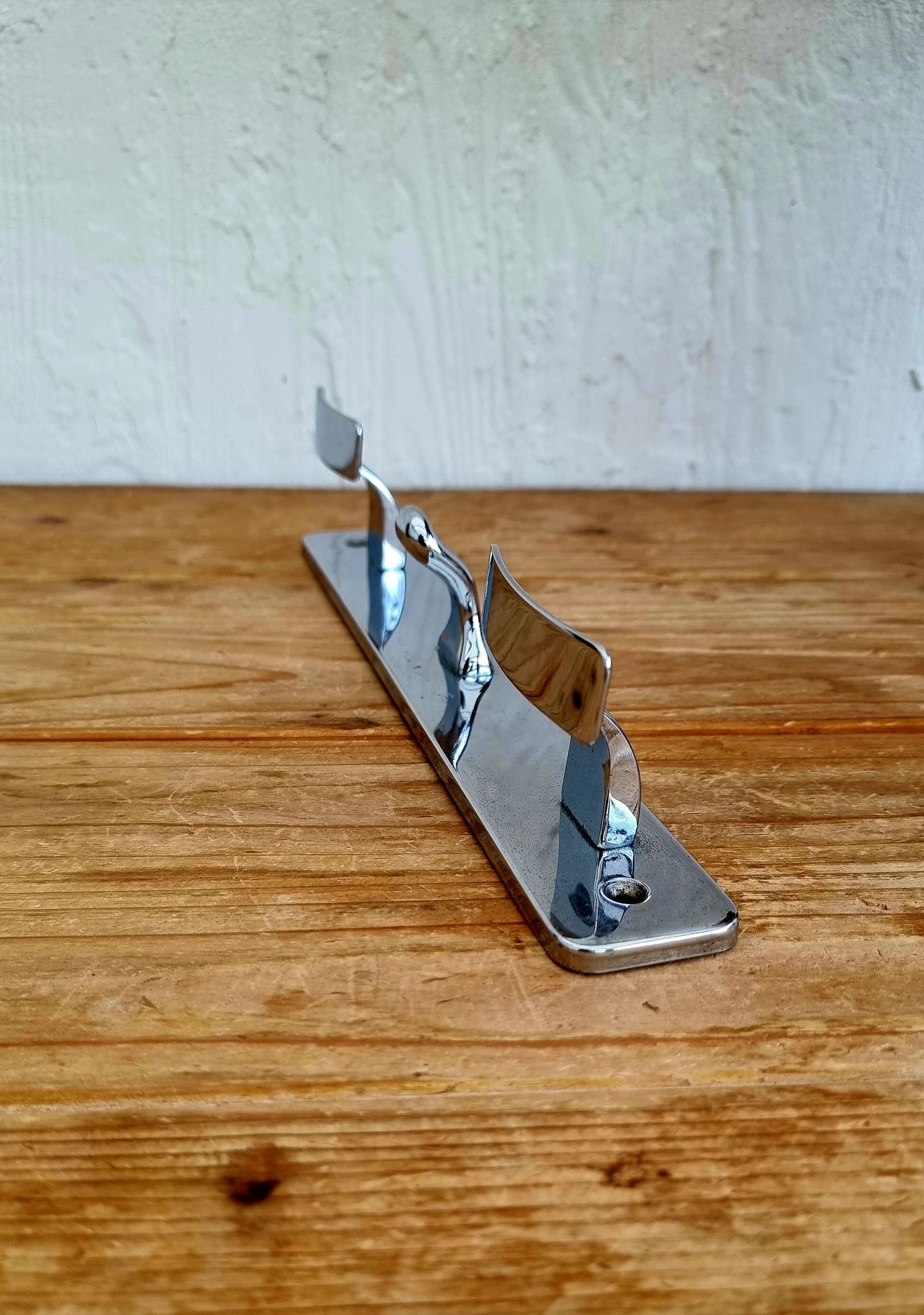 Vintage chrome wall coat rack with three hooks.