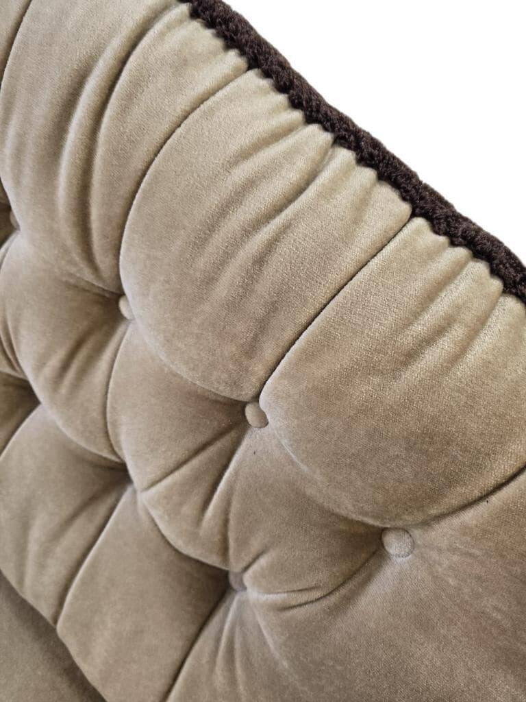 Vintage beige two-seater canapé with fringes.