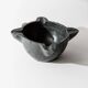 Vintage ceramic ashtray from the 1960s, black, hand-sculpted texture, organic shape.