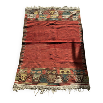 Small wool rug, predominantly red with geometric patterns
