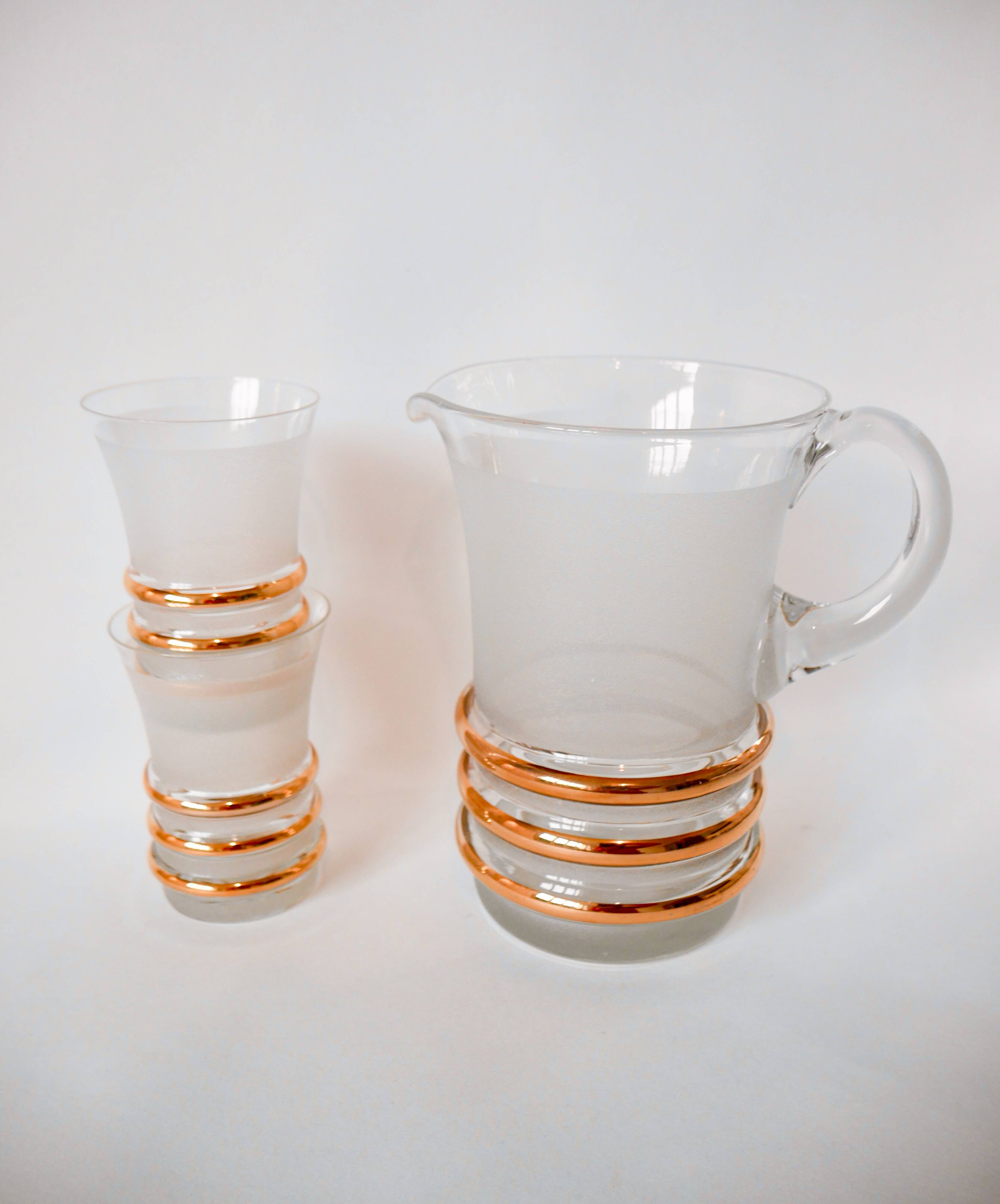 set composed of a pitcher and two large white granite glasses with gold edging from the 60s