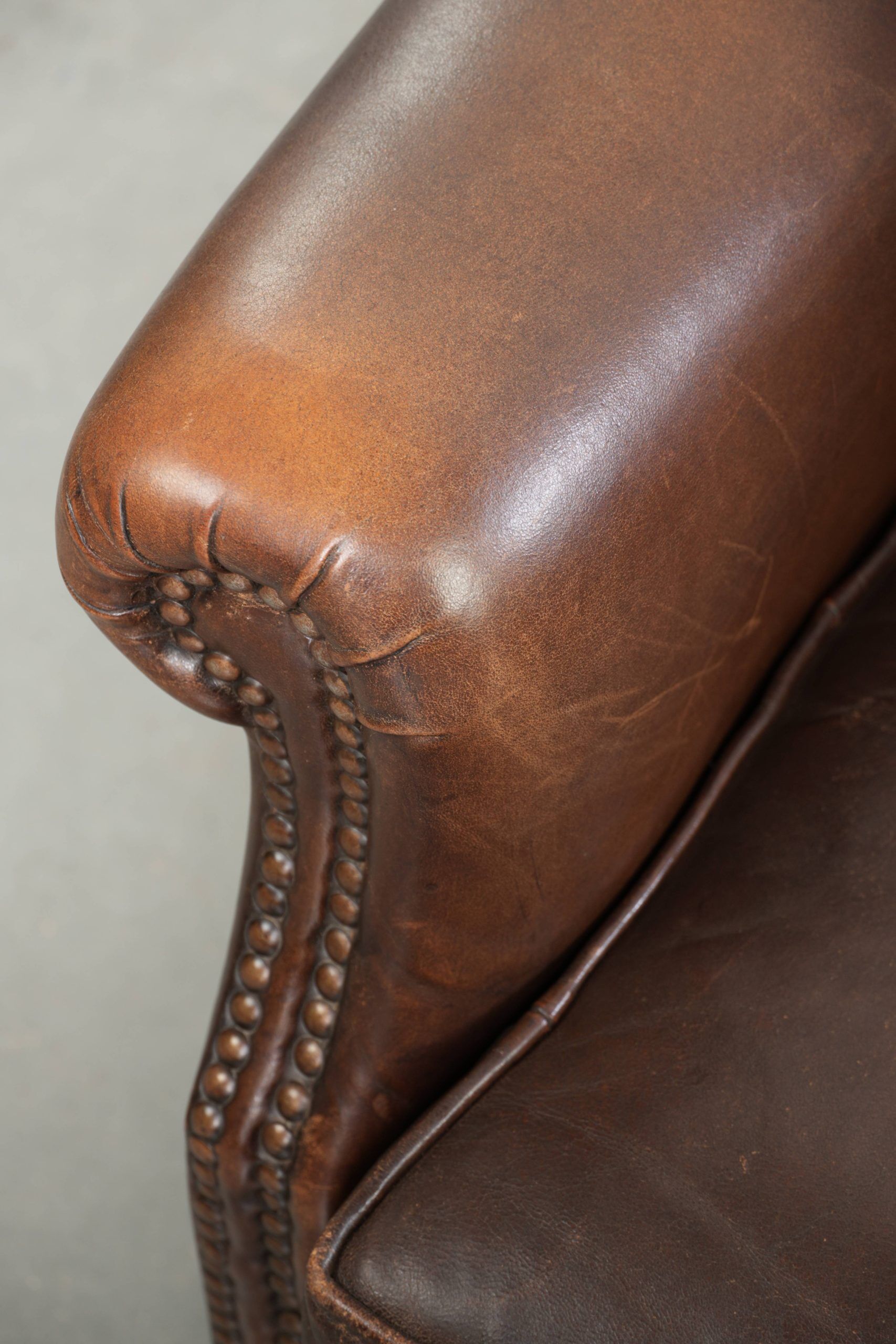 Subtle sheepskin wingback armchair with a deep cognac colour