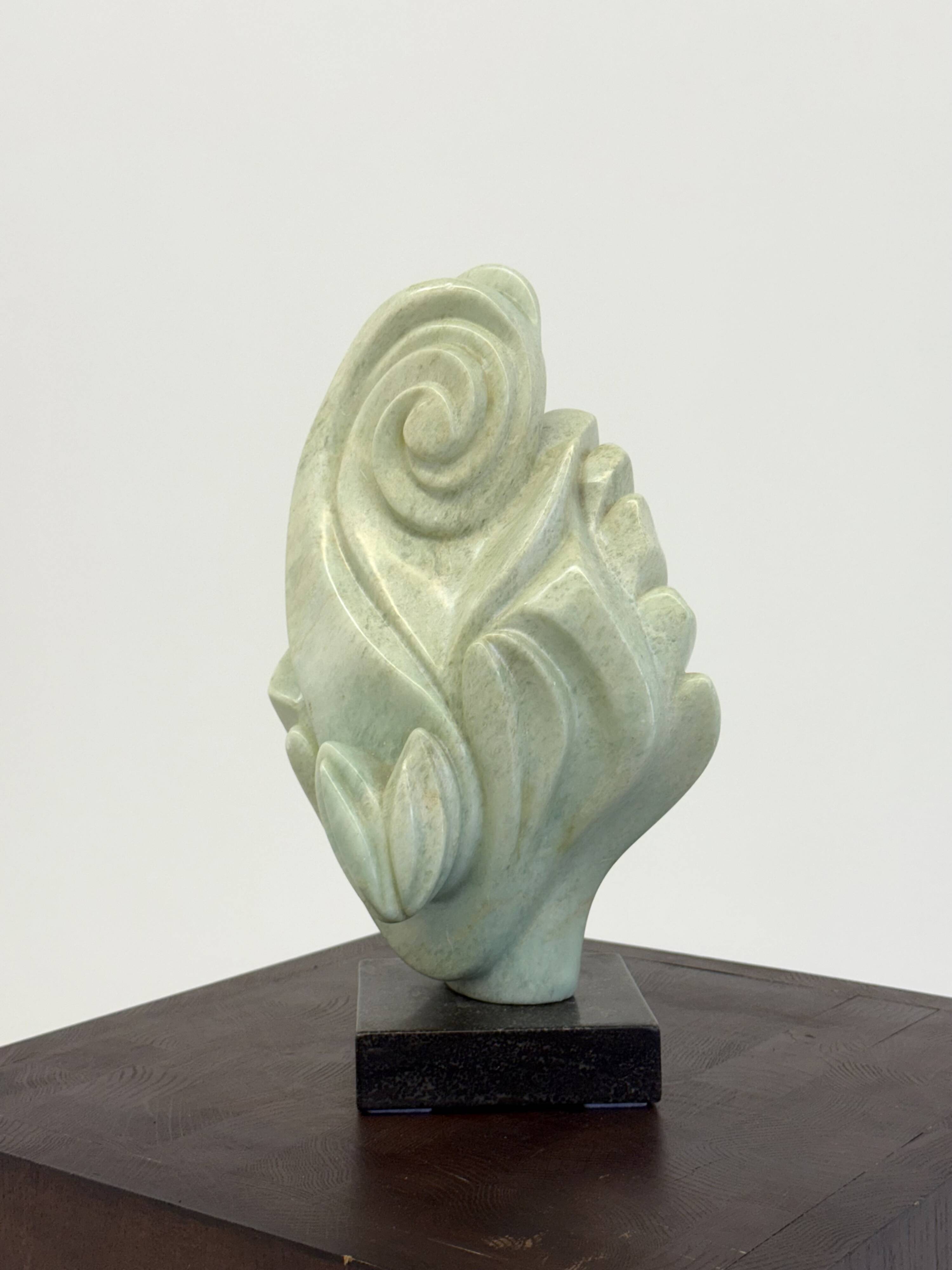 Green natural stone sculpture on marble base