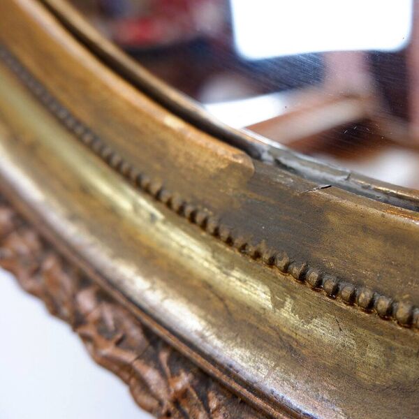 Wear consistent with age and use  Wood and gilded plaster ''Noeud d'Amour'' Oval mirror
