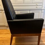 Modernist armchair in wood and black synthetic leather, circa 1960
