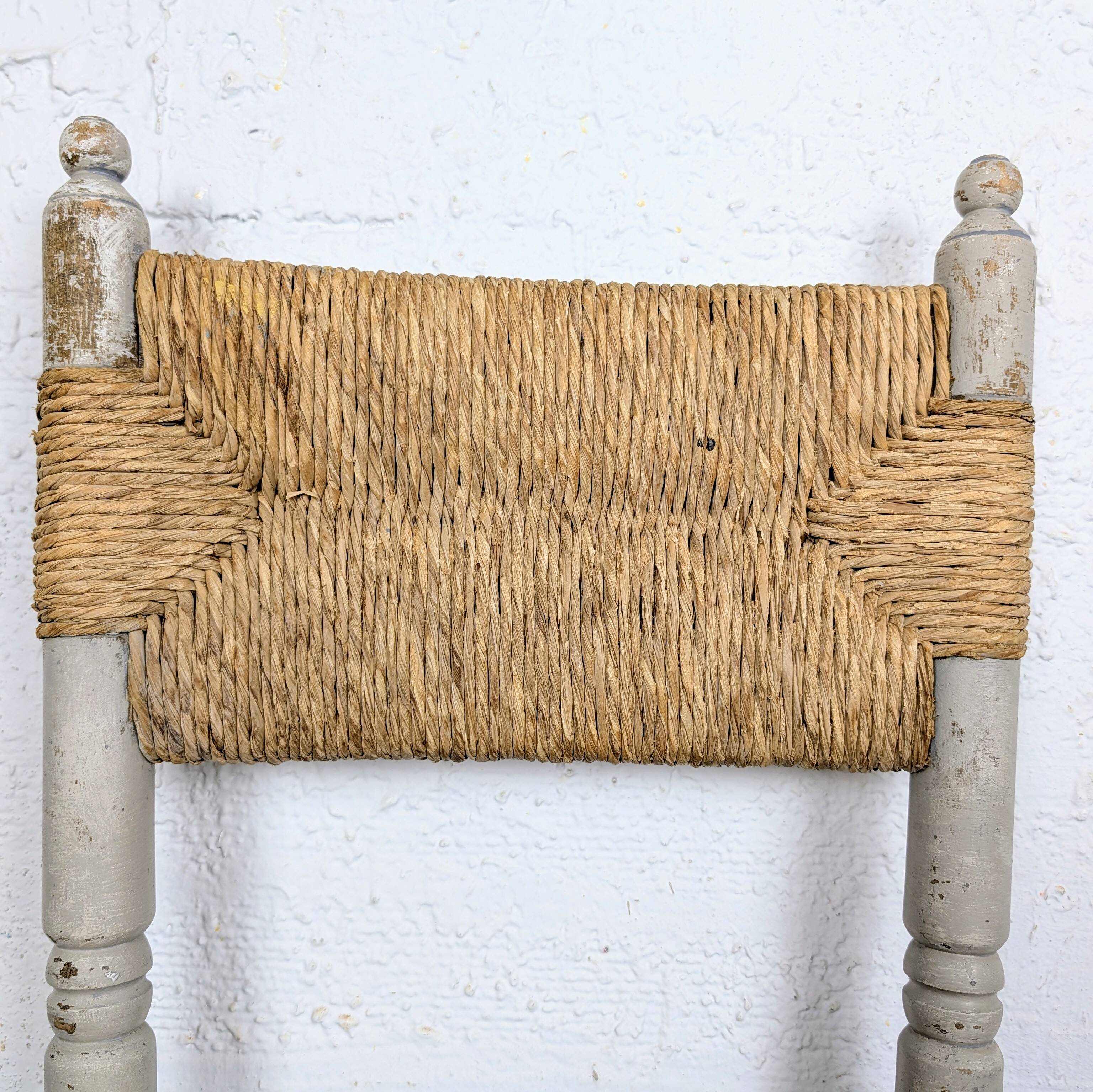 Rustic chair made of turned wood and straw.