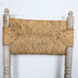 Rustic chair made of turned wood and straw.