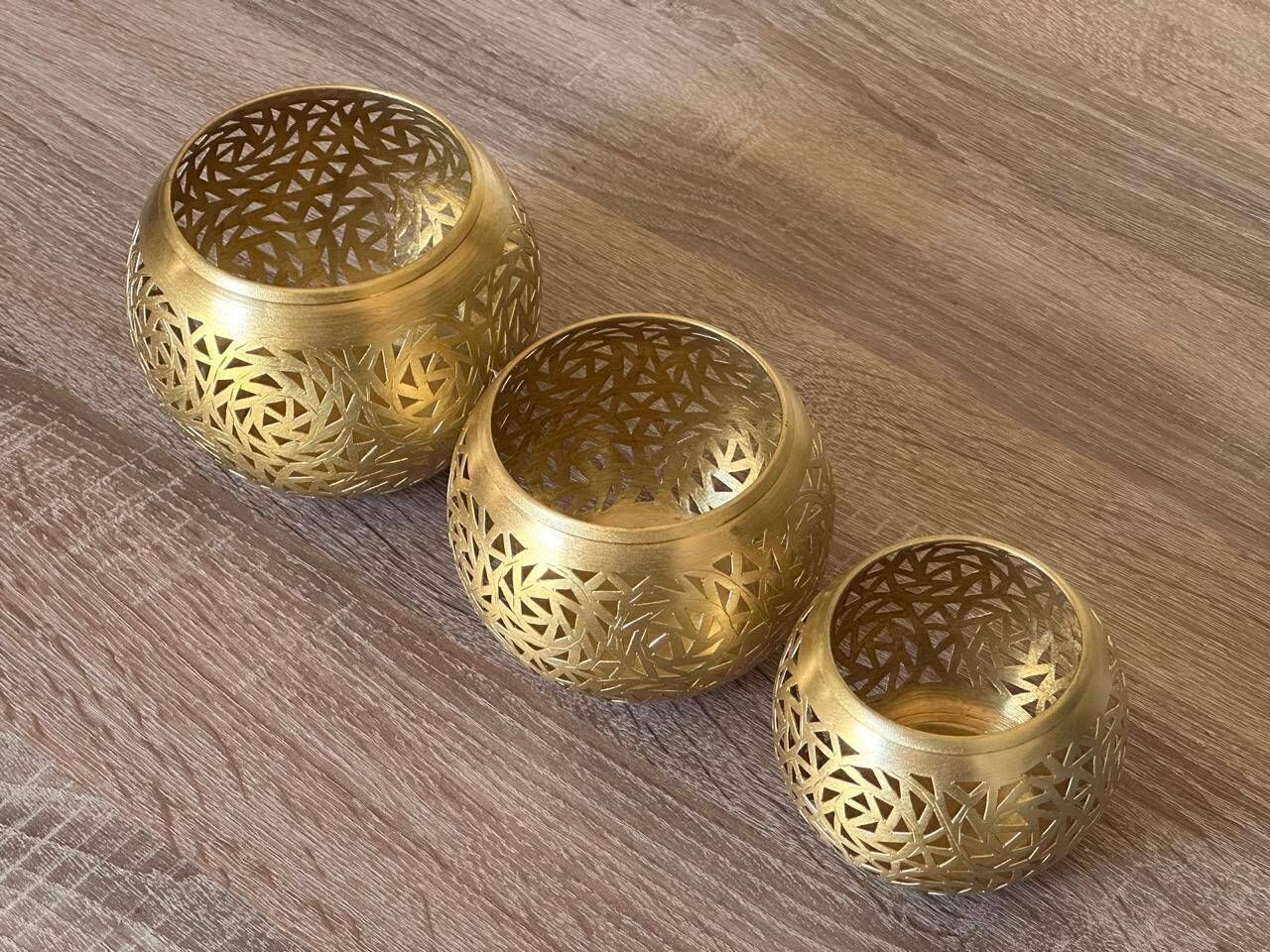 Set of 3 handmade brass candle holders with an openwork pattern.