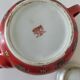 Vintage red Chinese teapot decorated with dragons and symbols.