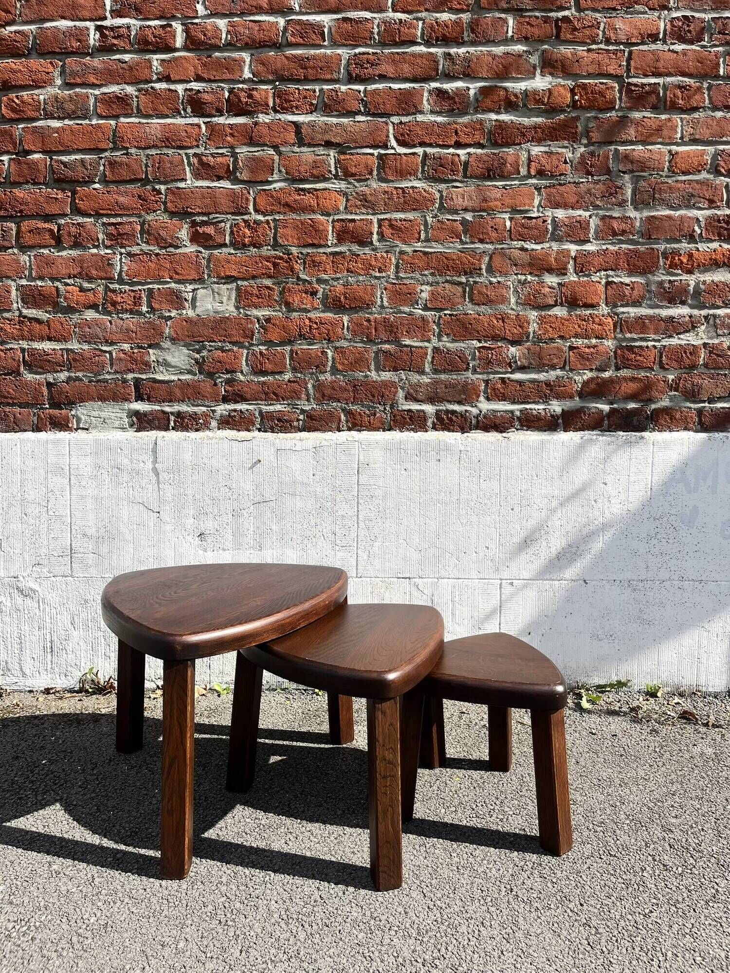Nested tripod tables made of solid wood, in a modernist brutalist style.