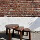 Nested tripod tables made of solid wood, in a modernist brutalist style.