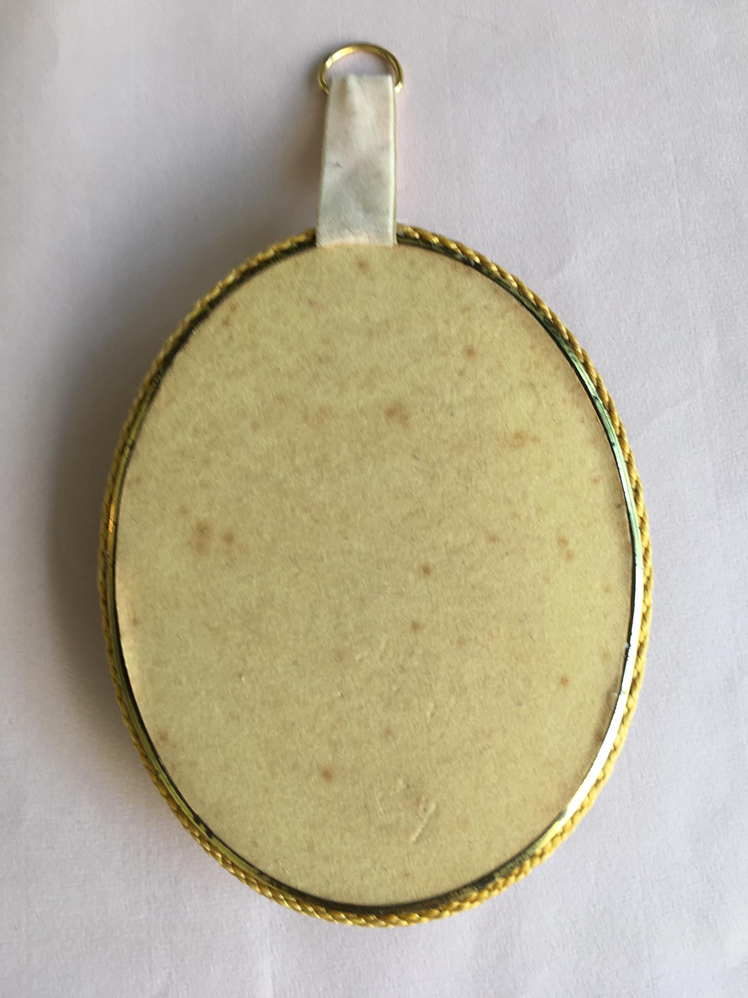Old medallion frame of dried flowers of oval shape. To hang with velvet stripe.