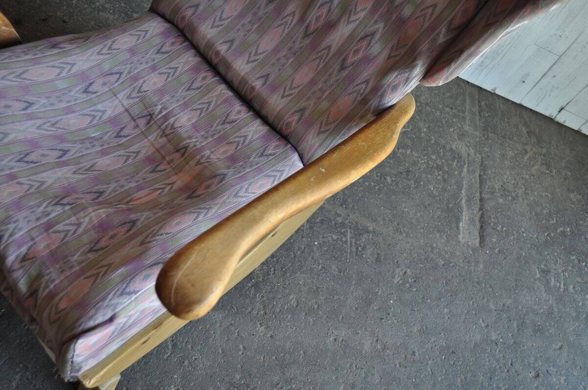 Vintage brown wooden rocking chair from the 1950s, wingback backrest and rocking base.
