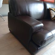 Two brown leather Crozatier two-and-a-half-seater sofas.