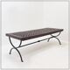 Solid wood coffee table with an openwork design and wrought iron legs.