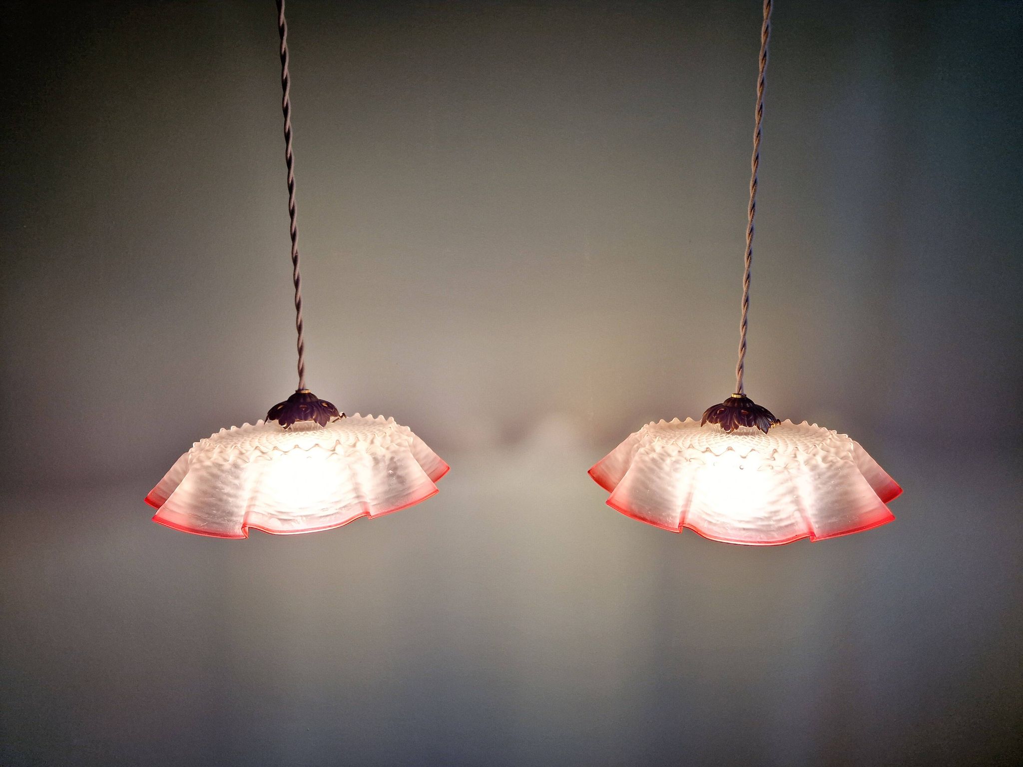 Pair of clear and pink satin glass scalloped pendant lights, 1920s-30s