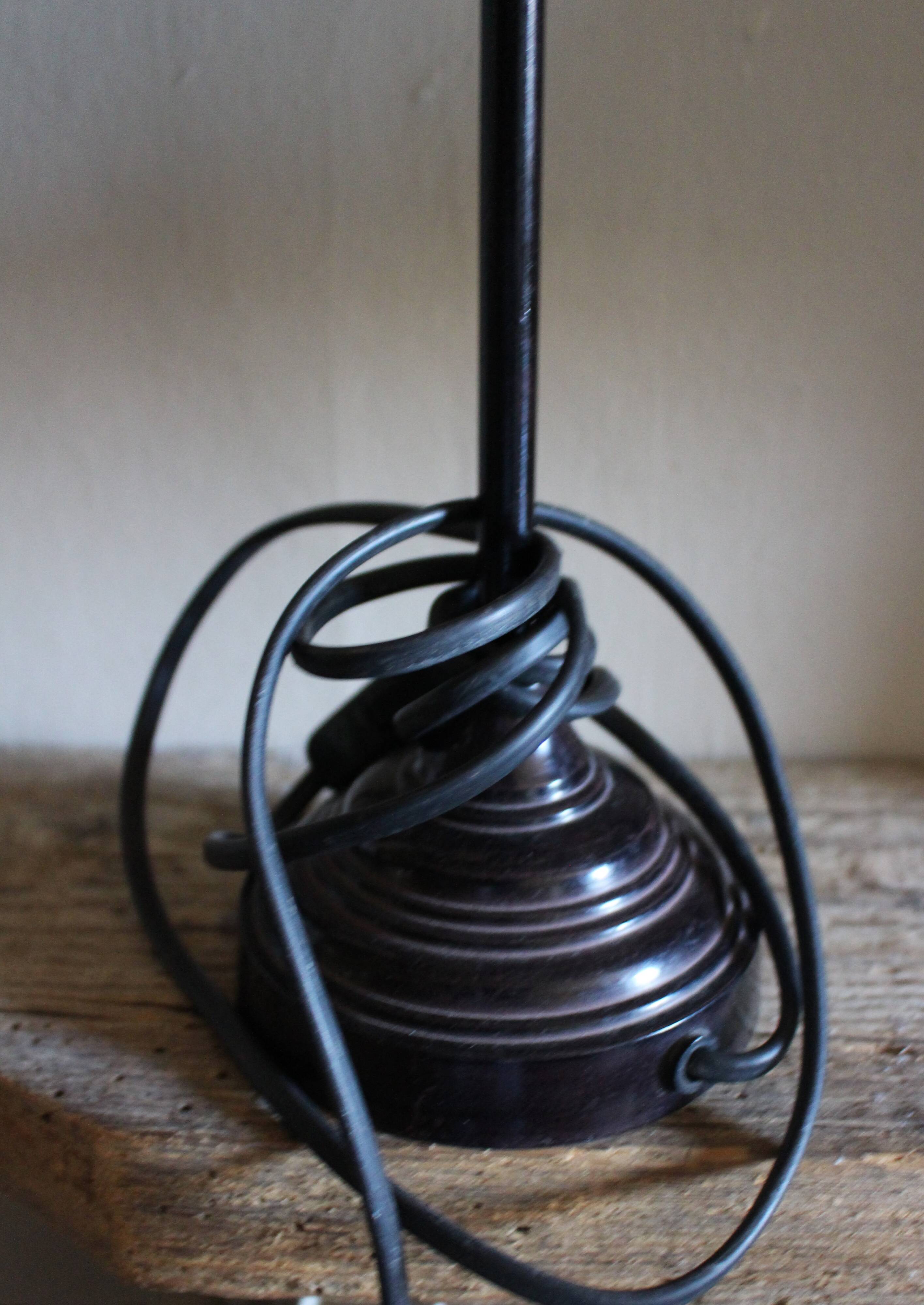 Table lamp with a patinated base and vintage woven shade.