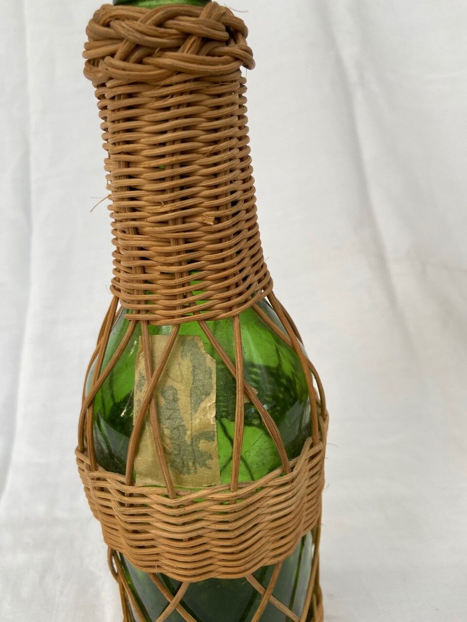 Green bottle with wicker decoration