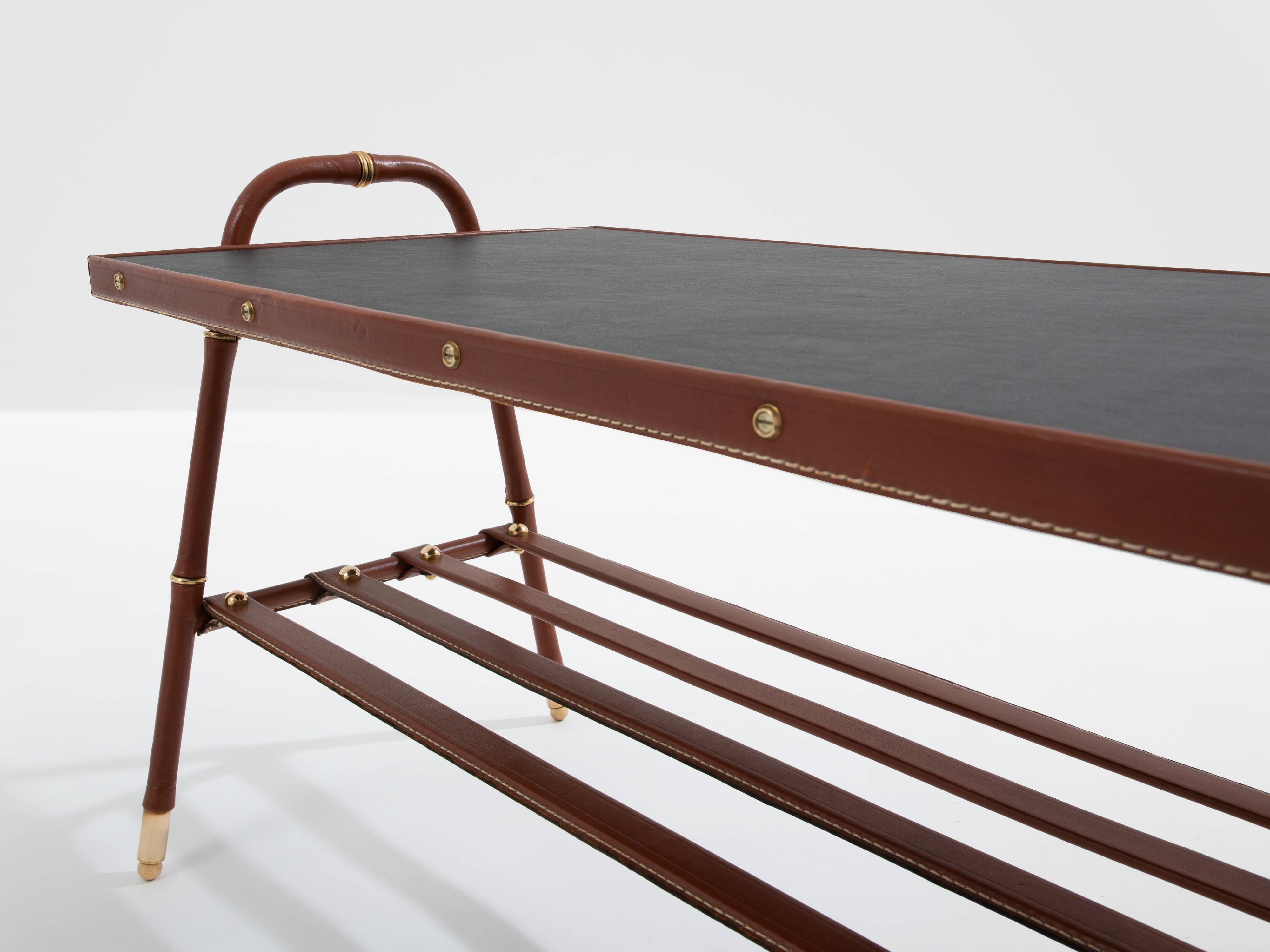 Jacques Adnet coffee table in red saddle-stitched leather and brass, 1950s