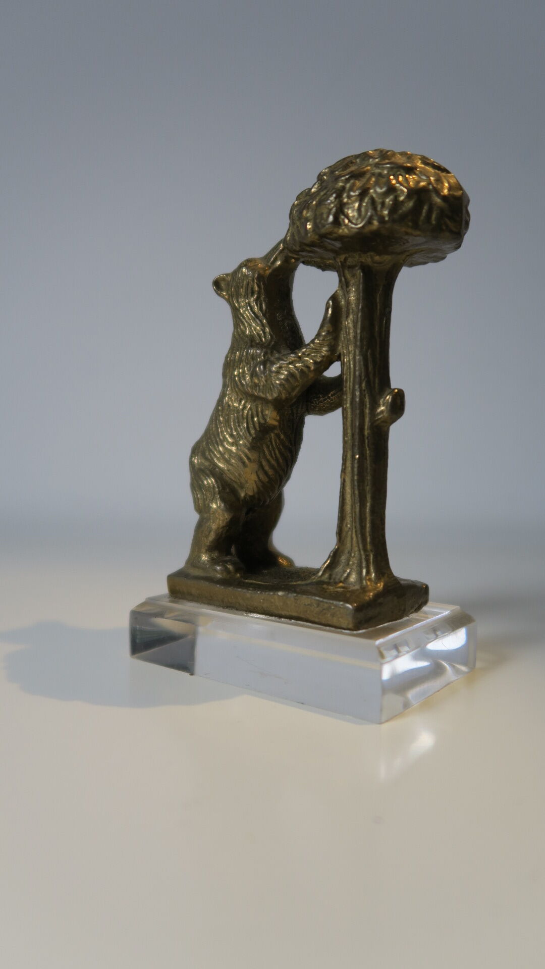 Brass sculpture, bear looking for honey in the tree