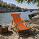 Vintage deck chair with orange and grey striped fabric, original patina.